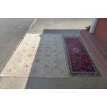 A Persian Kashgai hand made red ground rug and a Pakistani cream ground rug