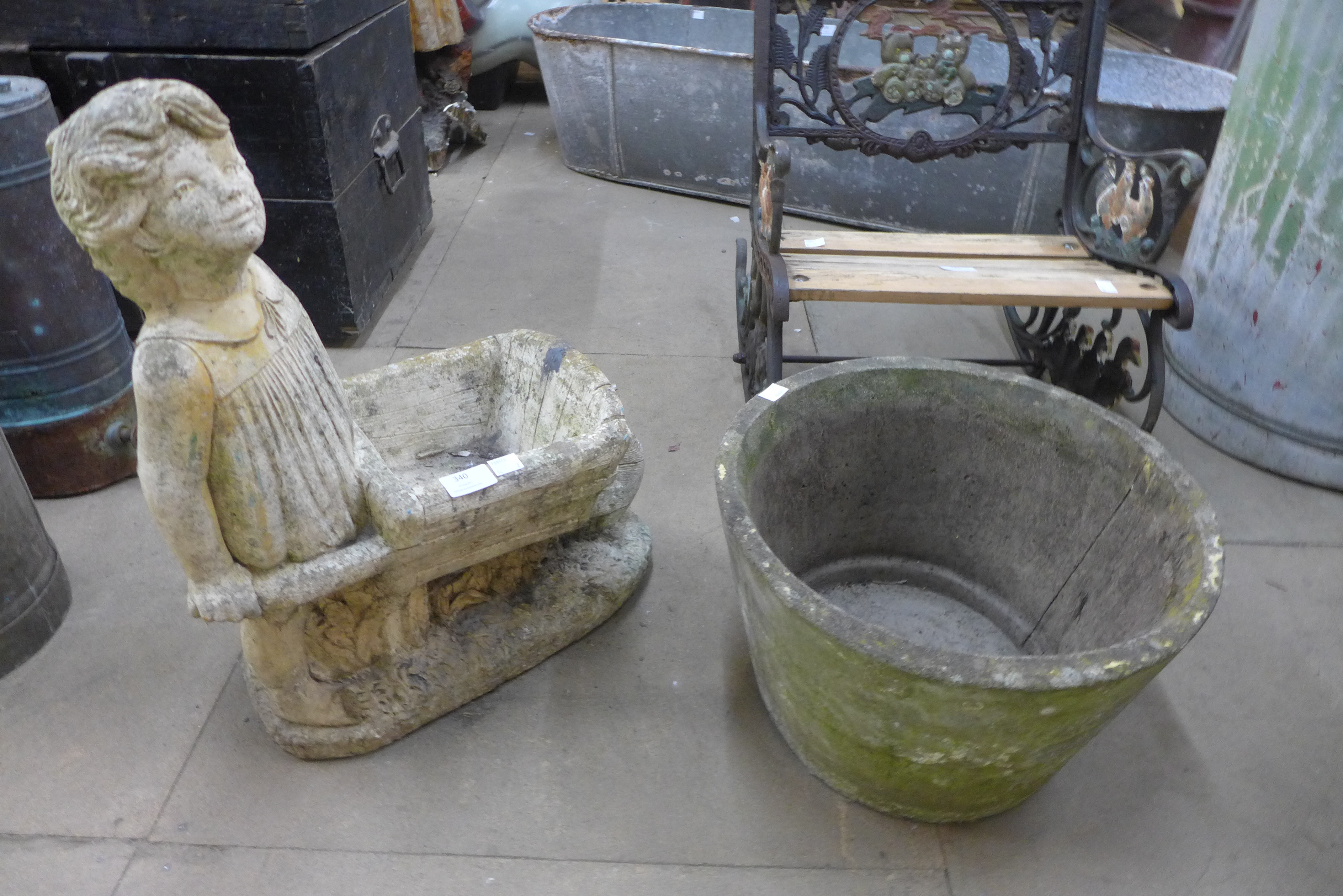 A figural concrete garden planter and another