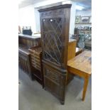 A carved oak freestanding corner cabinet