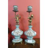 A pair of French style porcelain and ormolu mounted figural cherub candlesticks