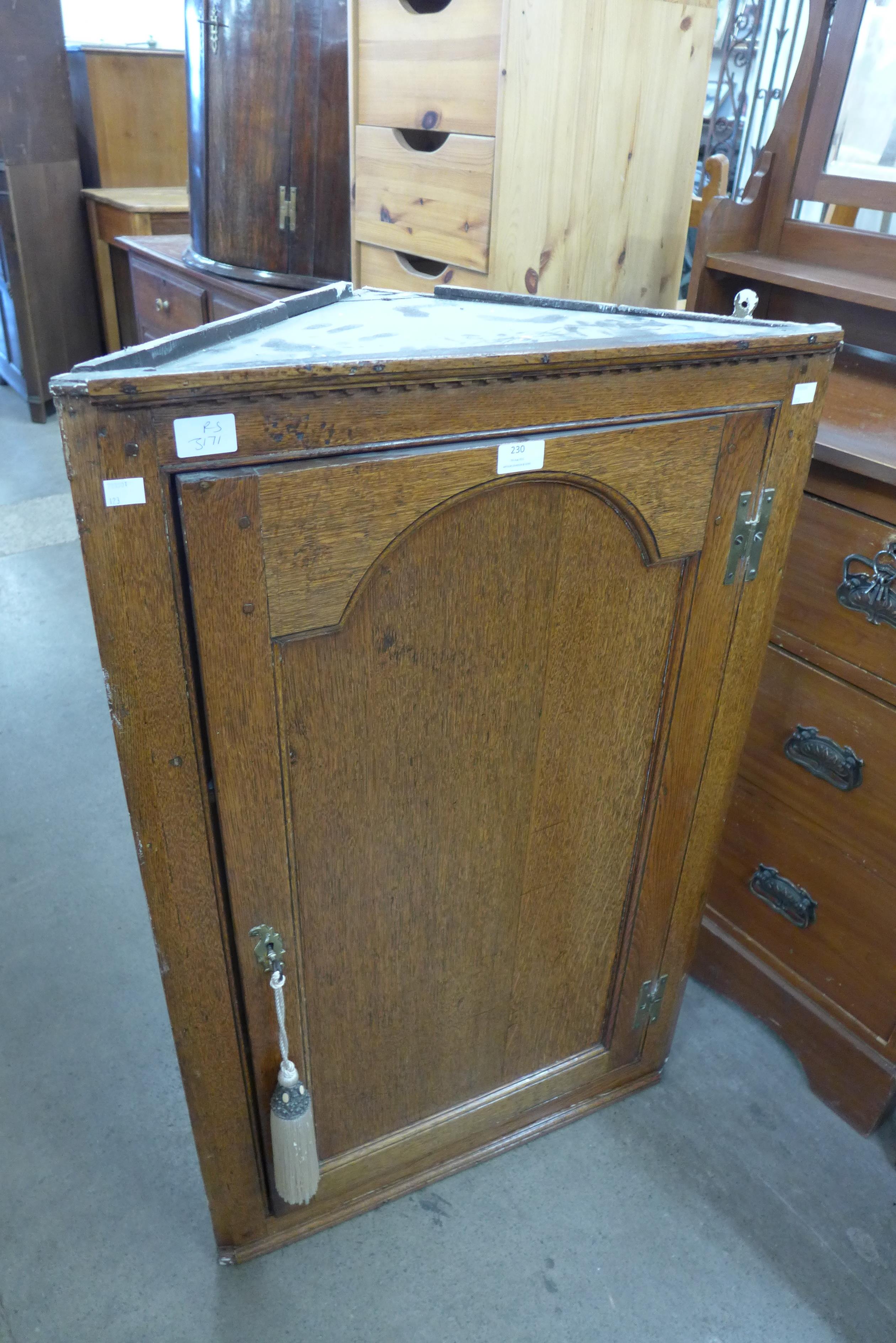 A George III oak hanging corner cabinet