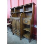 An Arts and Crafts oak open breakfront bookcase