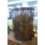 A George III oak and mahogany hanging corner cabinet