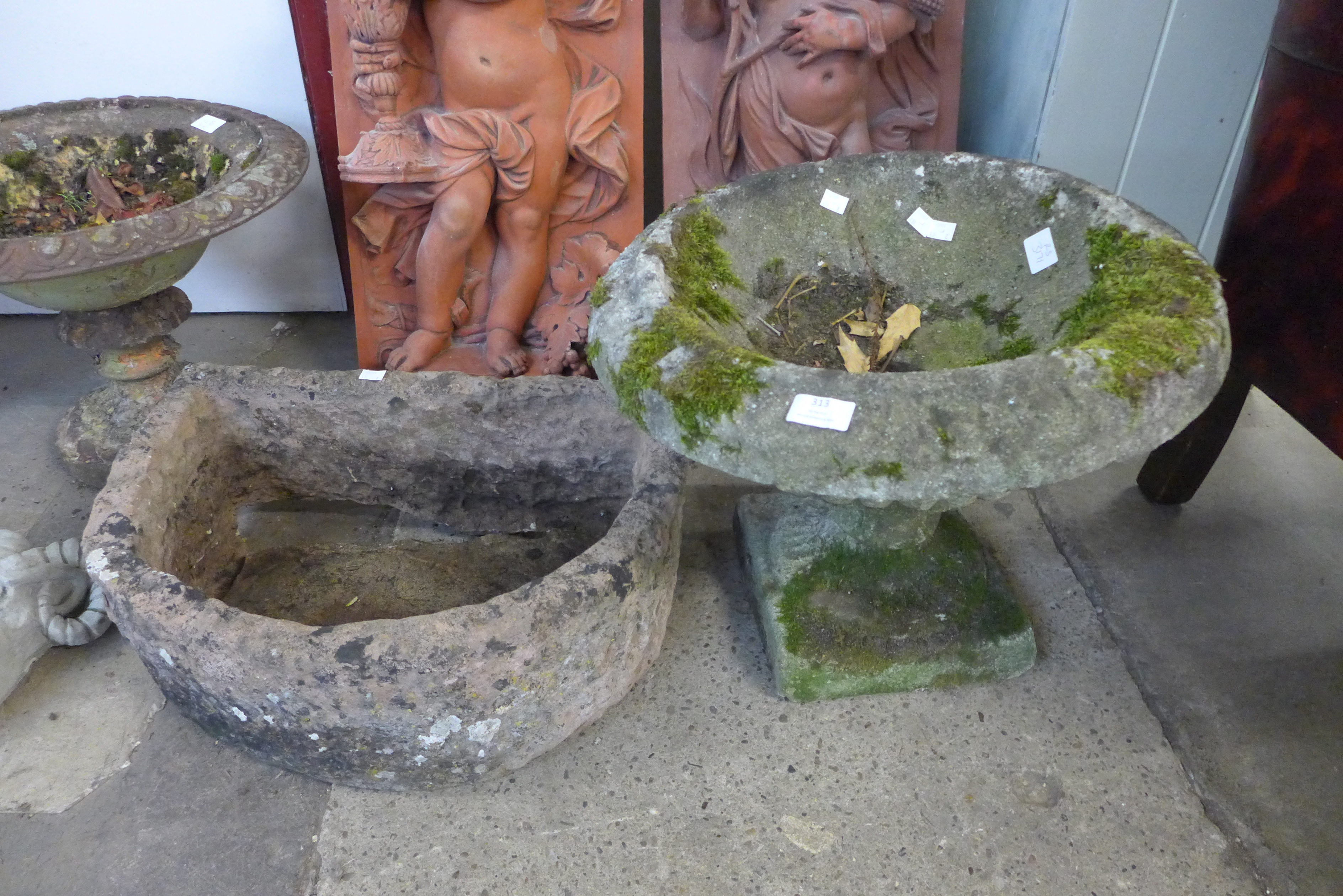 A concrete bird bath and a stone trough