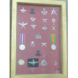 A collection of Ghurka badges and two WWII medals in a display case