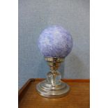 A blue glass globular table lamp on chrome base