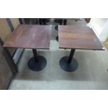 A pair of oak and steel based bistro tables