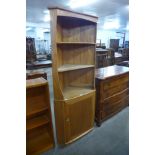 An Ercol Blonde elm and beech freestanding corner cabinet