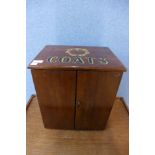 A small mahogany two door counter top shop cabinet, bearing later Coats painted inscription