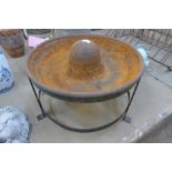 A cast iron Mexican hat pig feeder on stand