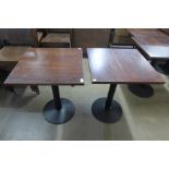 A pair of oak and steel based bistro tables