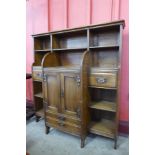 An Arts and Crafts oak open breakfront bookcase