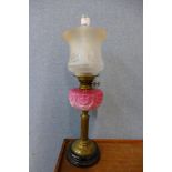 A Victorian brass oil lamp, with pink glass reservoir