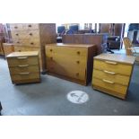 A teak chest of drawers and a pair of Austin Suite simulated teak bedside chests