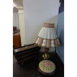 An oak and brass table lamp, embroidered footstool and an oak magazine rack
