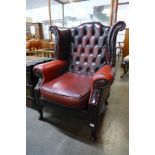 A mahogany and red leather buttoned wingback armchair