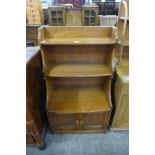 A small Ercol Golden Dawn elm and beech two door bookcase