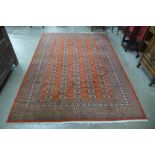 A Pakistani hand knotted red ground Bokhara rug, 268 x 195cms