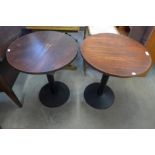 A pair of circular oak and steel based bistro tables