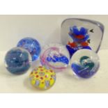 An Italian Murano aquarium paperweight and five other glass paperweights