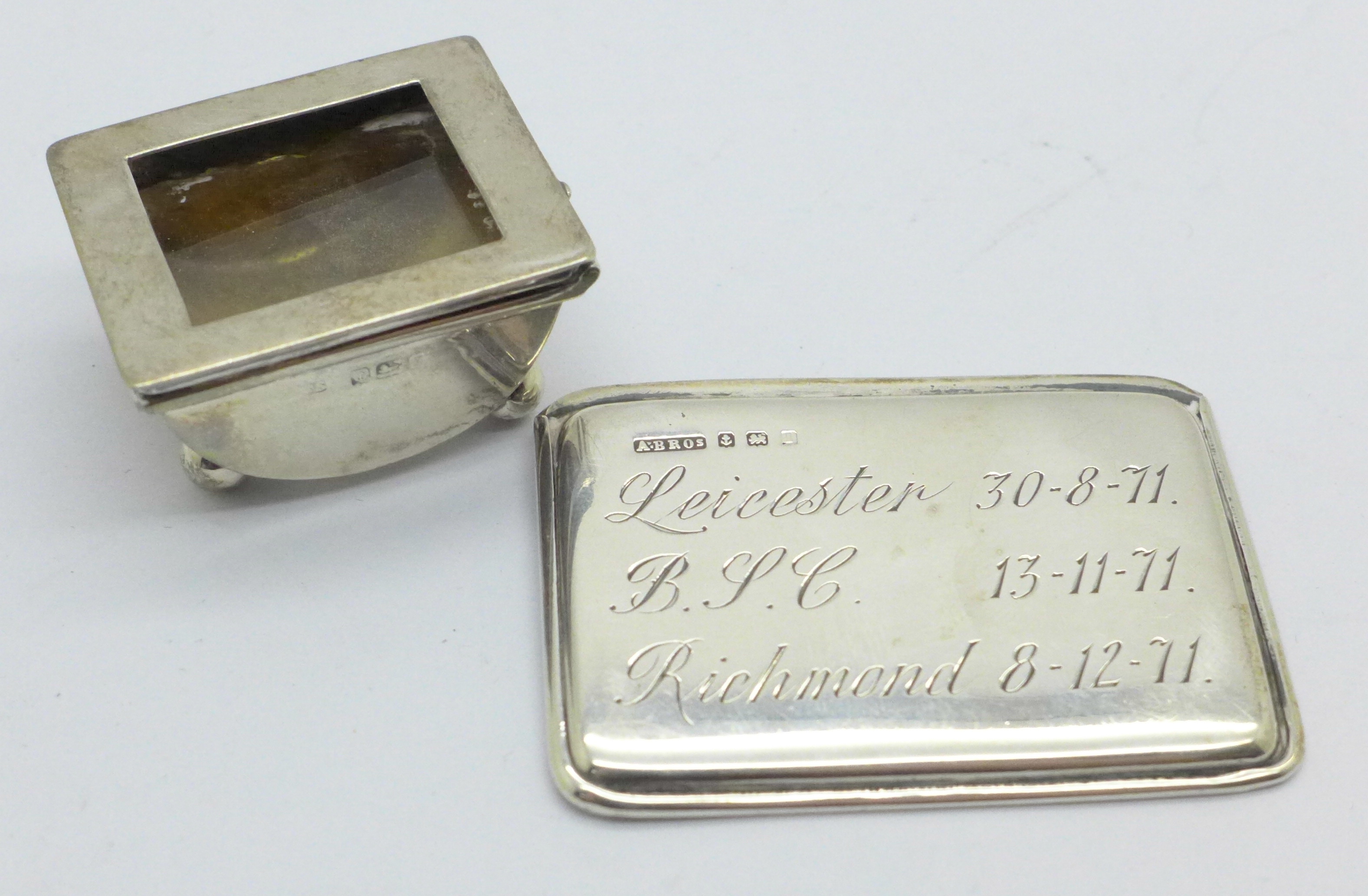 A silver stamp holder with cabochon red stone, slide to open, Birmingham 1910, with inscription