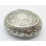 An oval white metal box with hinged lid, width 7cm