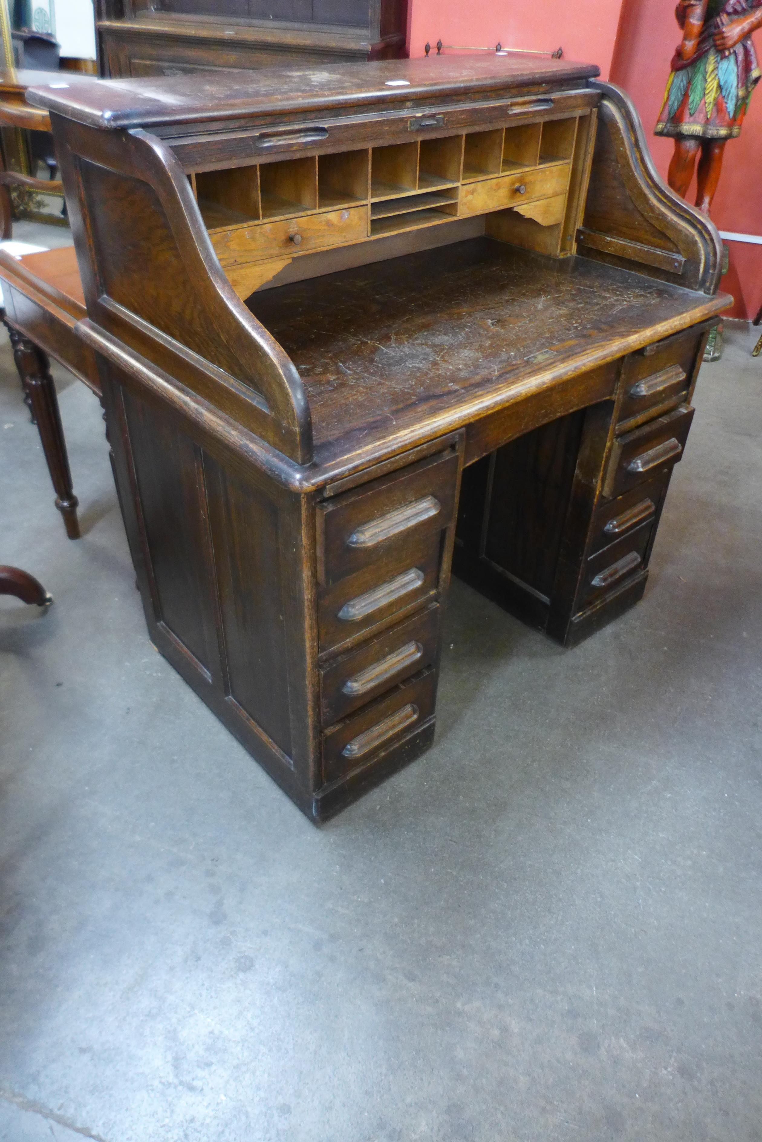 An early 20th Century oak tambour roll top desk