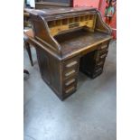 An early 20th Century oak tambour roll top desk