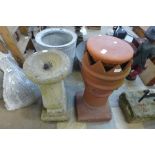 A terracotta chimney-pot and a concrete bird bath