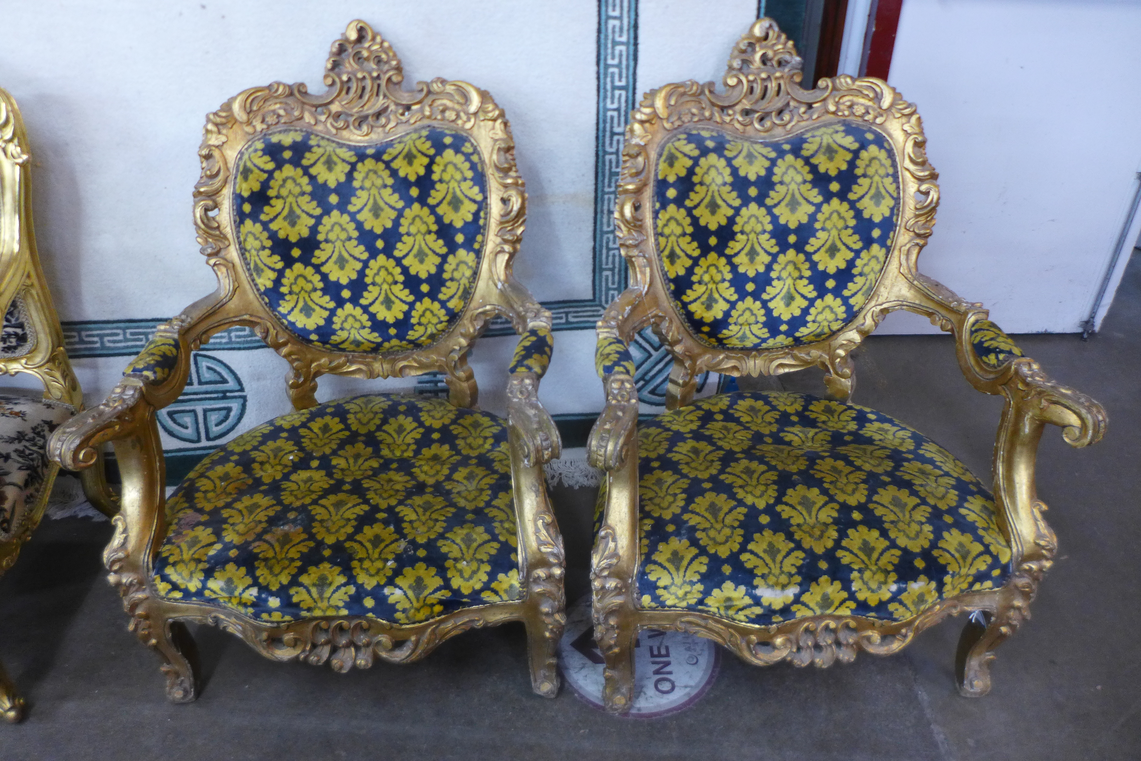 A pair of French Louis XV style giltwood and fabric upholstered fauteuils