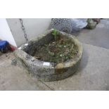 A reconstituted stone D-shaped garden trough