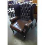 A mahogany and chestnut brown leather wingback armchair