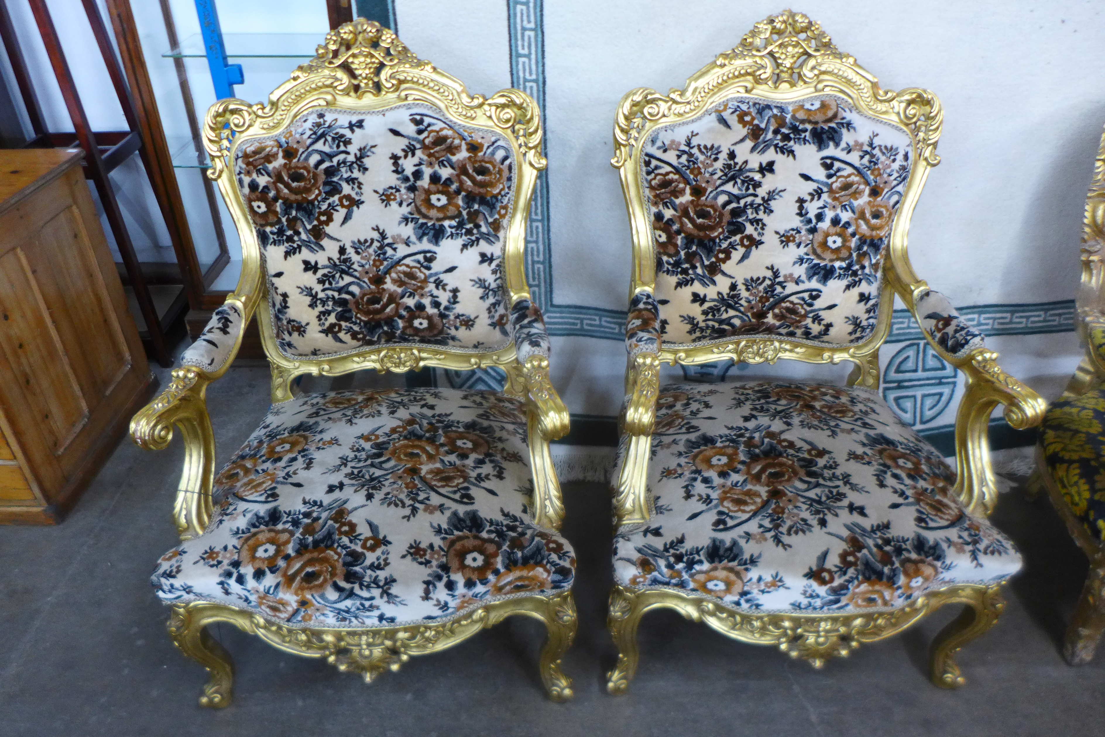 A pair of French Louis XV style giltwood and fabric upholstered fauteuils