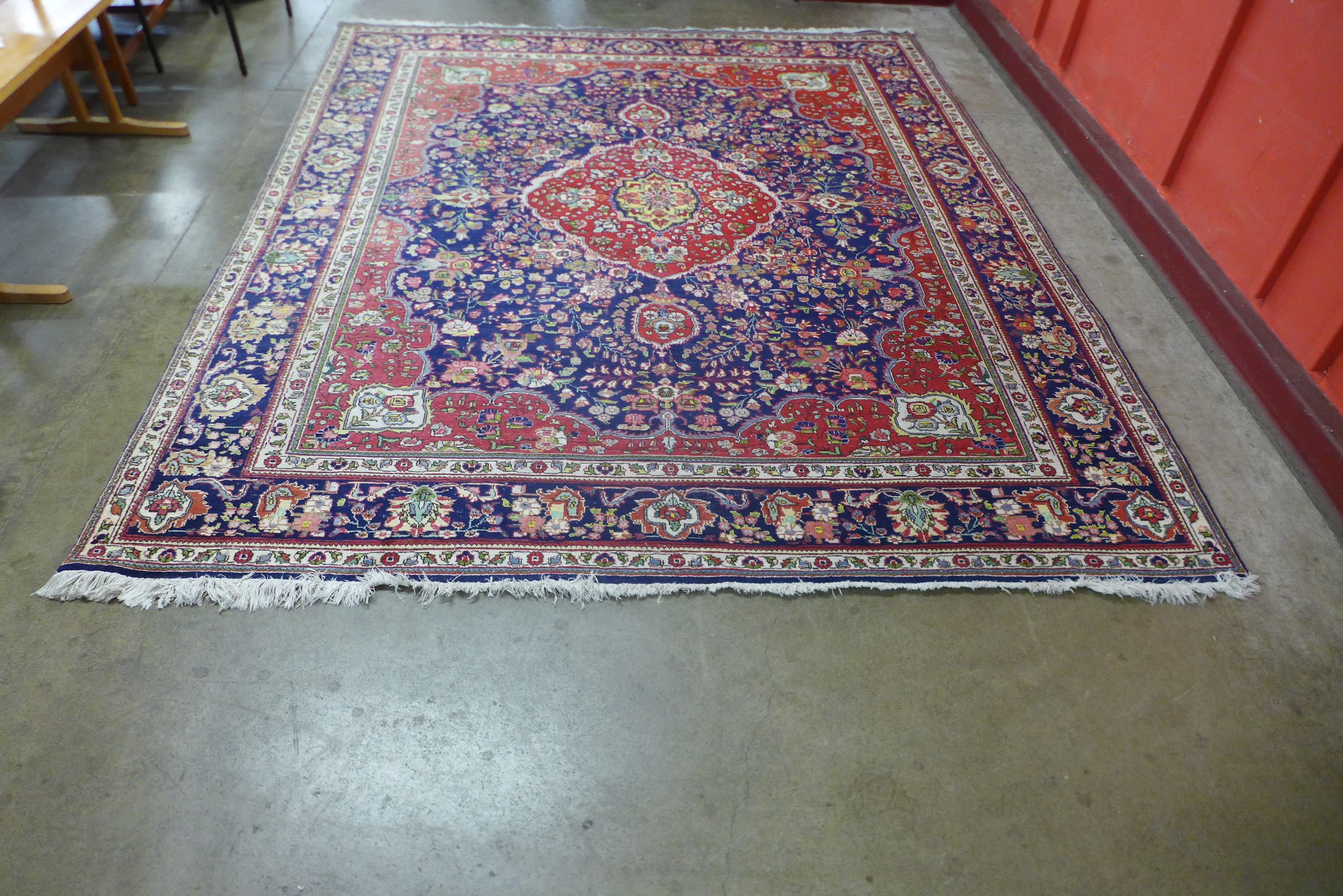 A large Persian red ground geometric patterned Tabriz rug, 355 x 304cms