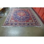 A large Persian red ground geometric patterned Tabriz rug, 355 x 304cms