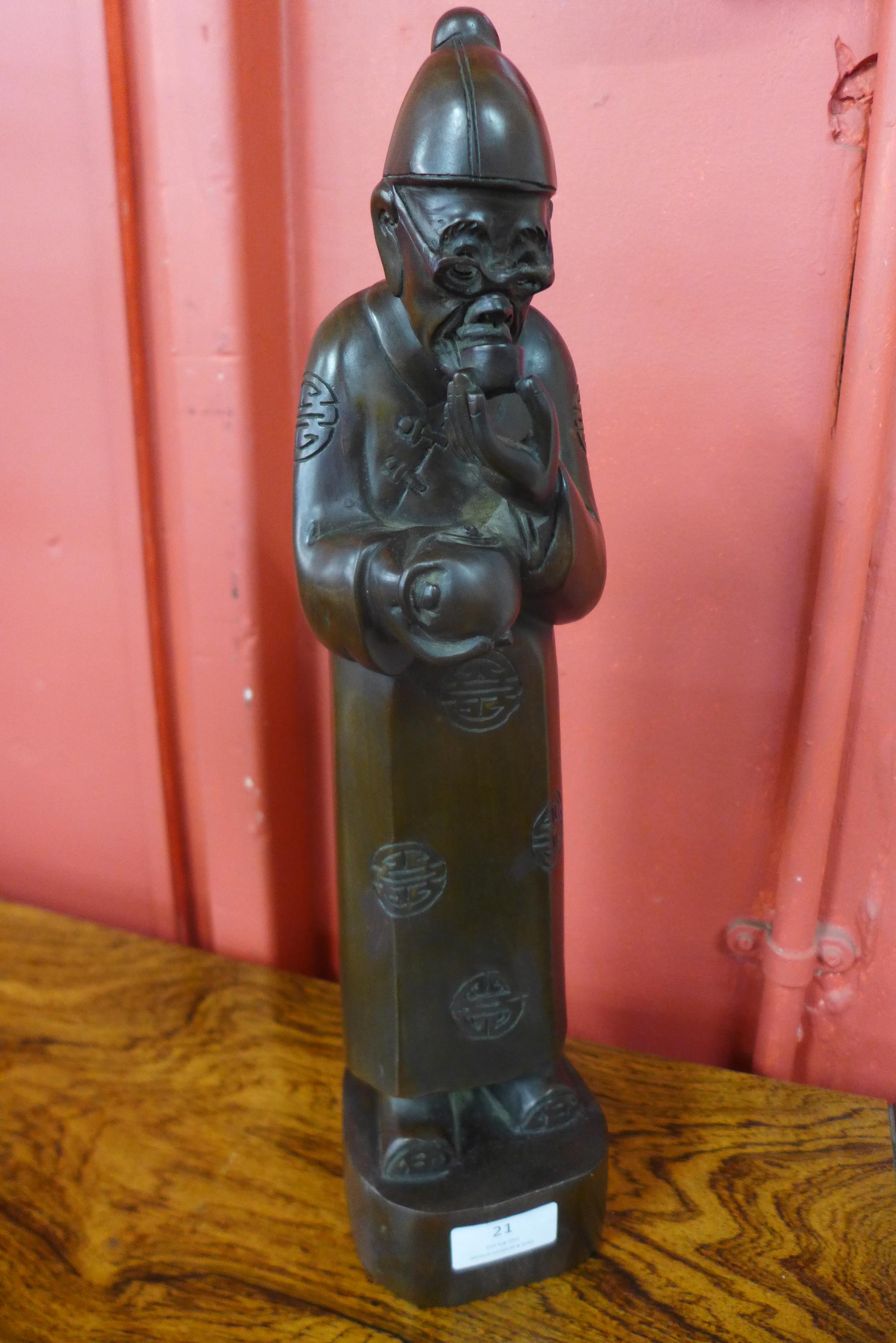 An oriental carved hardwood figure of a sage