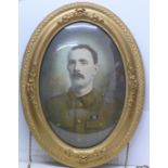 An oval gilt framed coloured photograph of a WWI soldier awarded the Military Medal