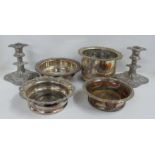 A collection of plated ware including a pair of dwarf candlesticks and two wine coasters