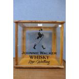 A light oak table top display case, bearing later Johnnie Walker Whisky inscription to glass