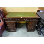A mahogany and green leather desk