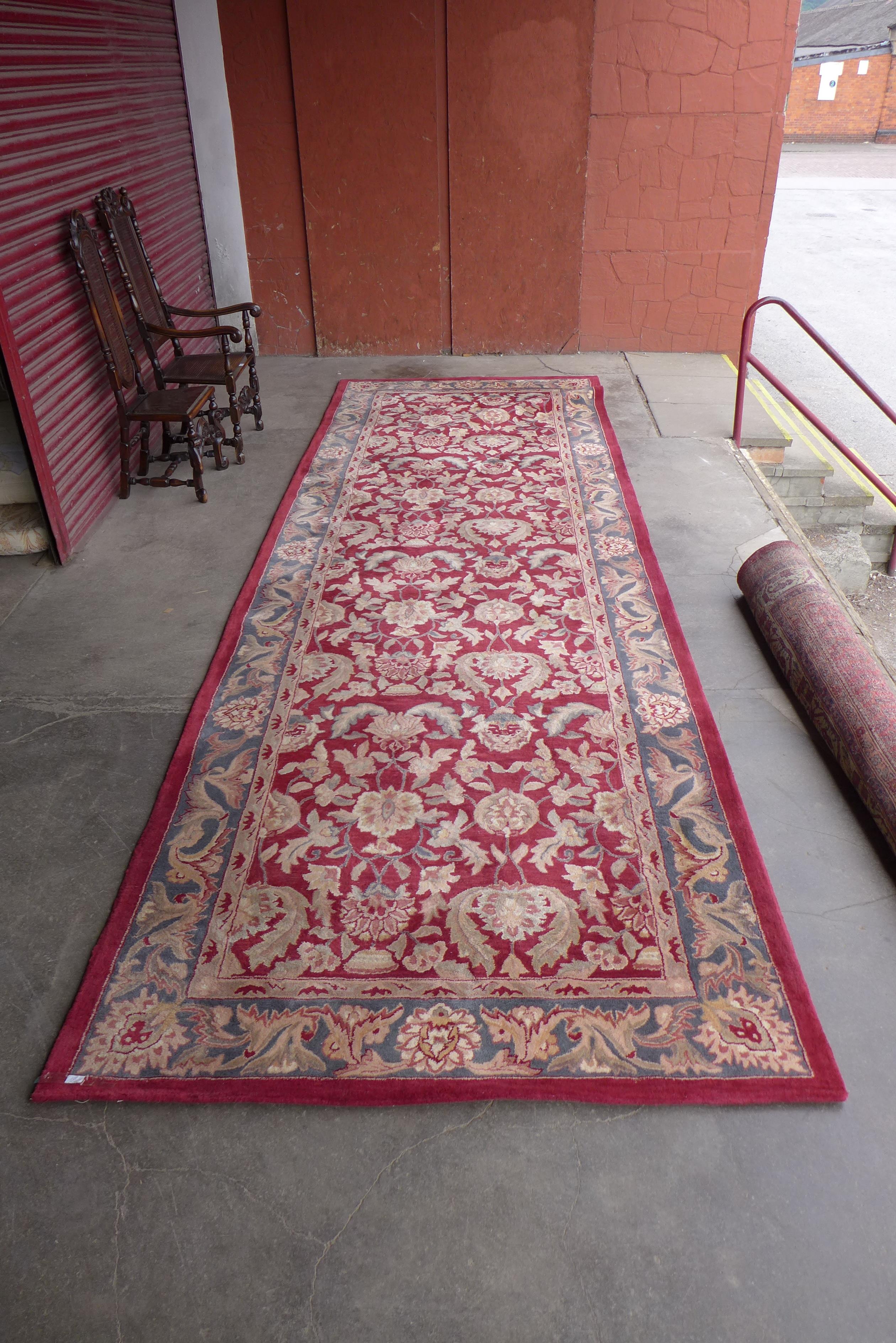 A red ground geometric patterned rug, 516 x 172cms