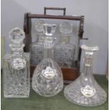 A two bottle tantalus and three crystal decanters, whisky decanter with chip to rim