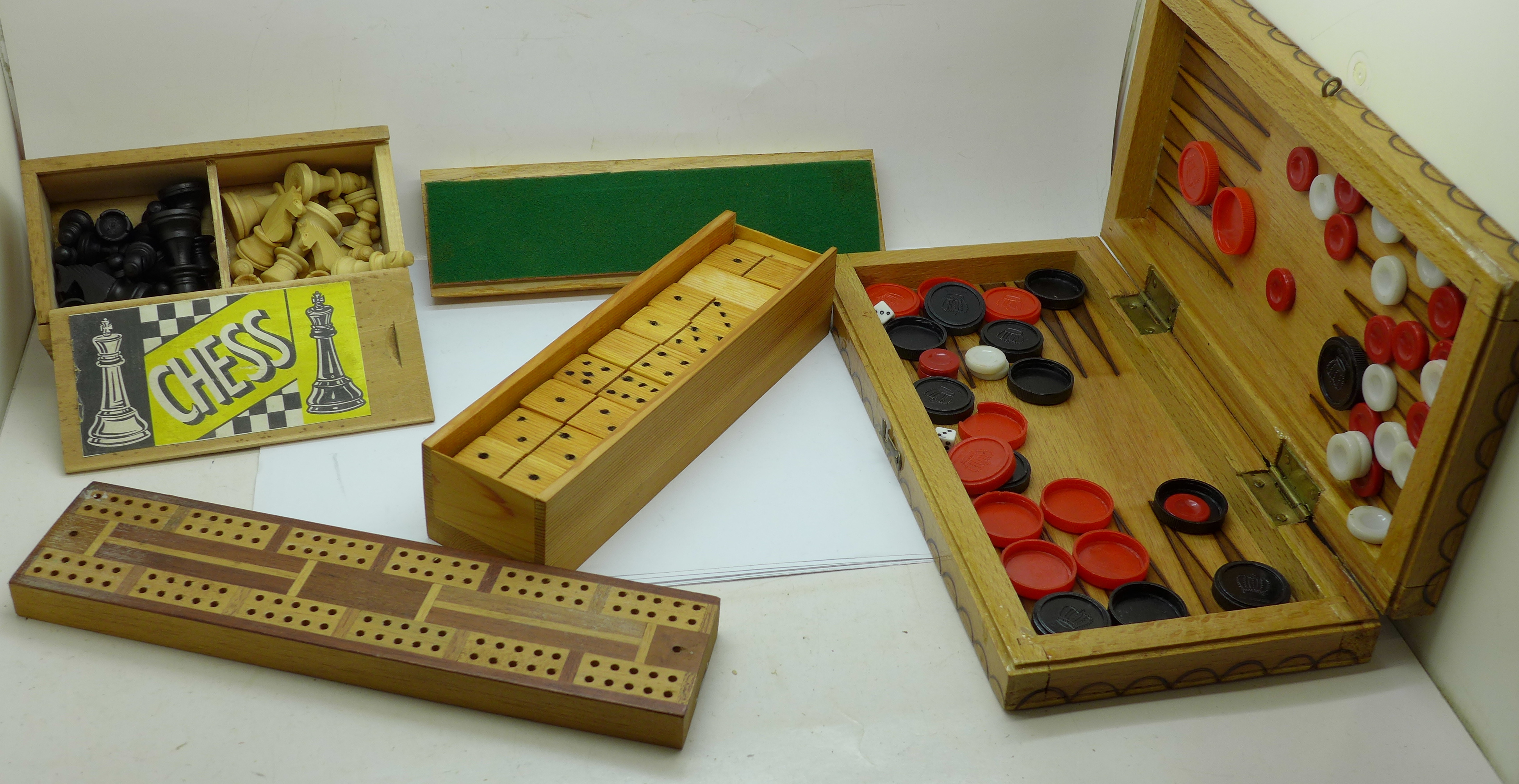 A collection of games including a chess set, cribbage board and dominoes