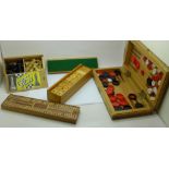 A collection of games including a chess set, cribbage board and dominoes