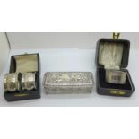 A silver topped glass box, a pair of silver napkin rings, boxed and a silver napkin ring, boxed,