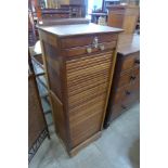 An oak tambour front filing cabinet