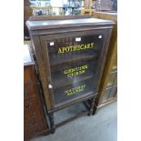 An early 20th Century oak cabinet, bearing Apothecary inscription to door