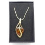 A silver gilt and amber pendant with chain