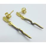 A pair of silver gilt serpent earrings, each set with one small black diamond