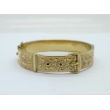 A 1/5th 9ct gold and metal core buckle bangle, dented on the back